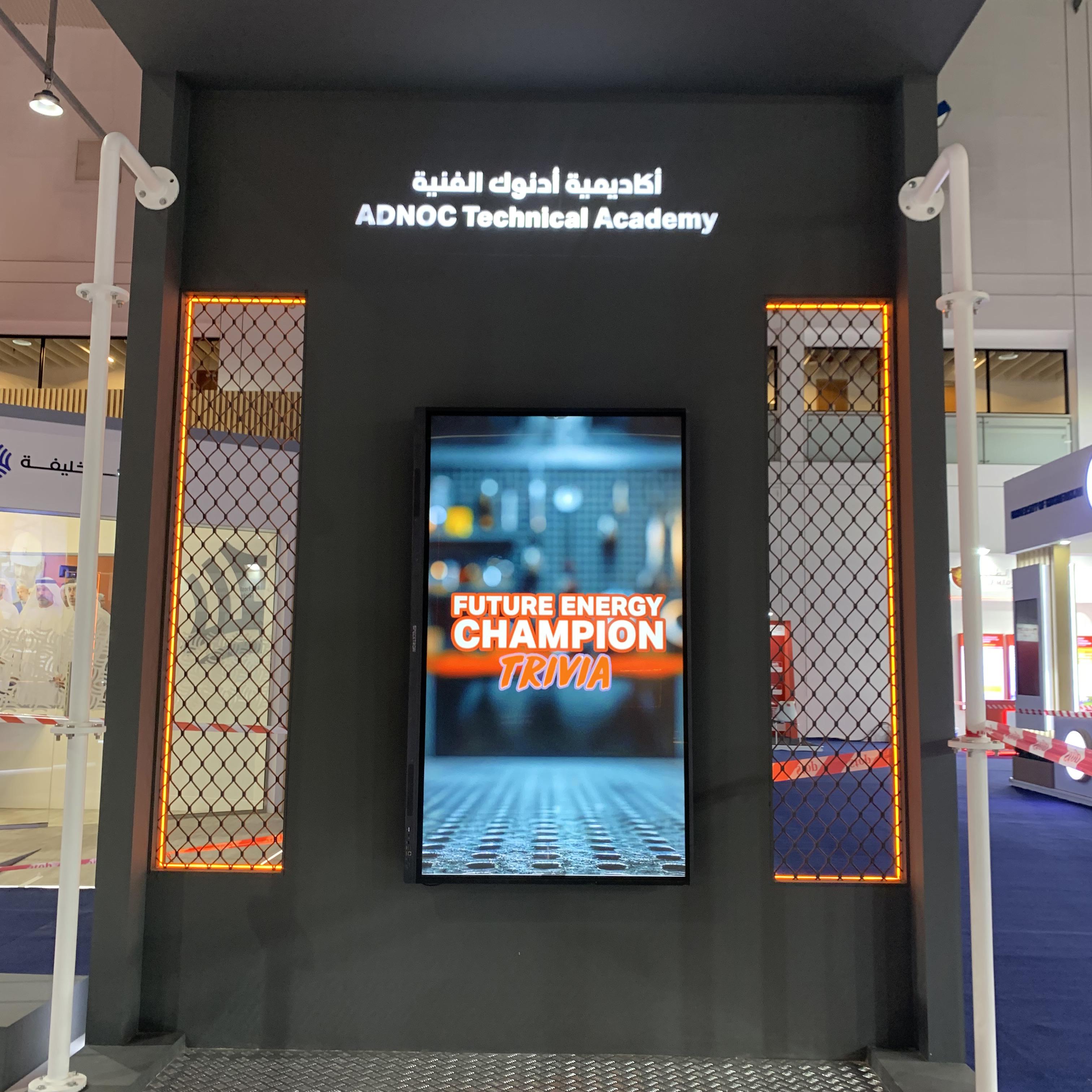 Students and guests play the Plinko Trivia Challenge at the ADNOC Technical Academy booth during a busy Dubai event